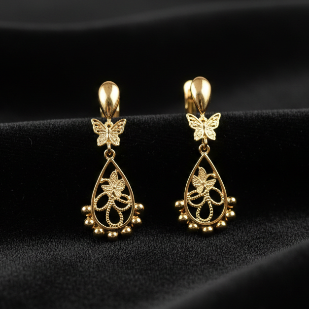 Generate a realistic image of girl's gold earring on black velvet cloth